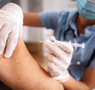 close-da-enfermeira-sentada-em-casa-e-aplicando-a-injecao-em-uma-mulher-idosa-durante-o-surto-de-corona-232070-10560
