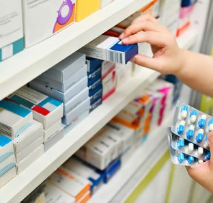 BIE - 16/09/2017 - Pharmacist holding medicine box and capsule pack in pharmacy drugstore.Estante de remédios de uma farmácia.Foto: MJ_Prototype